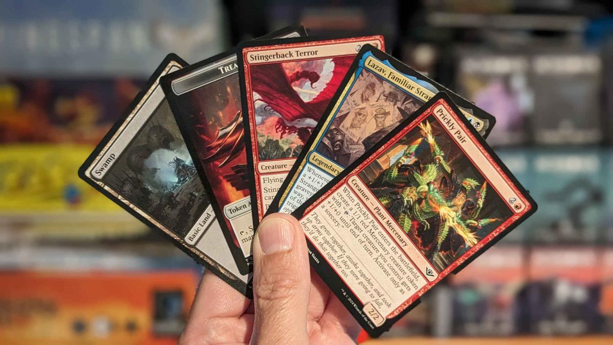 Hand holding five Magic: The Gathering cards